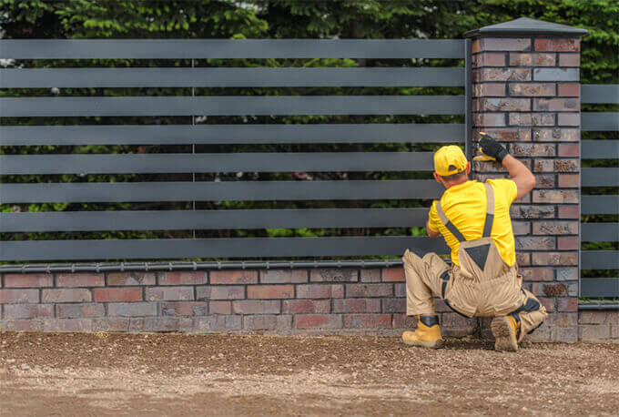 Worker installing a wooden fence