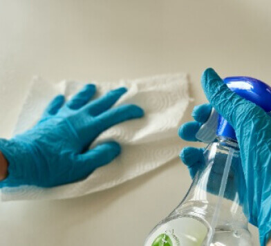 Gloved hand cleaning a surface